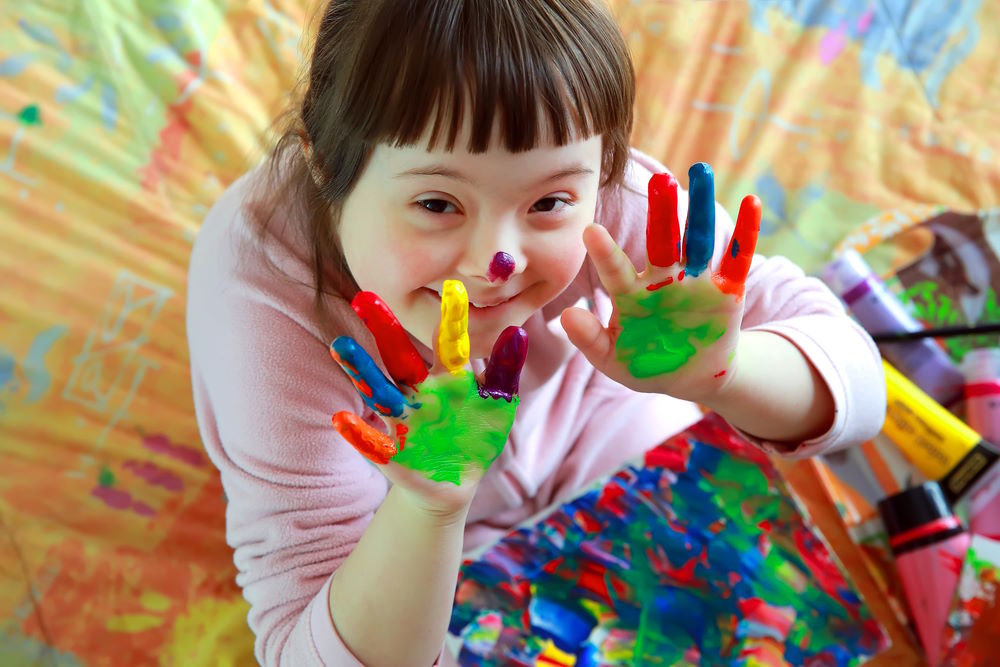 The picture below shows a young girl with Down Syndrome finger painting.